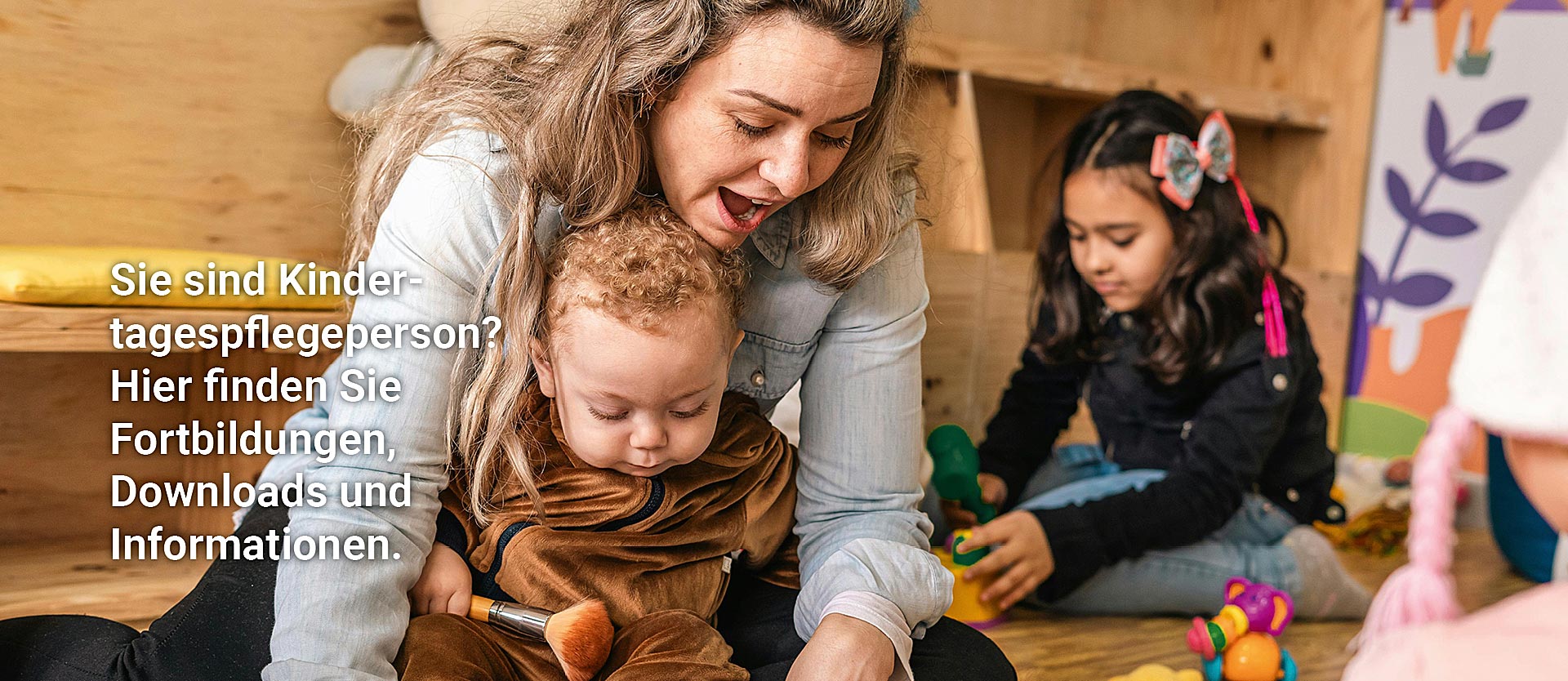 Erwachsene Frauen sitzen in einer Stuhlreihe, eine Frau hält eine rote Feder in der Hand und spricht.